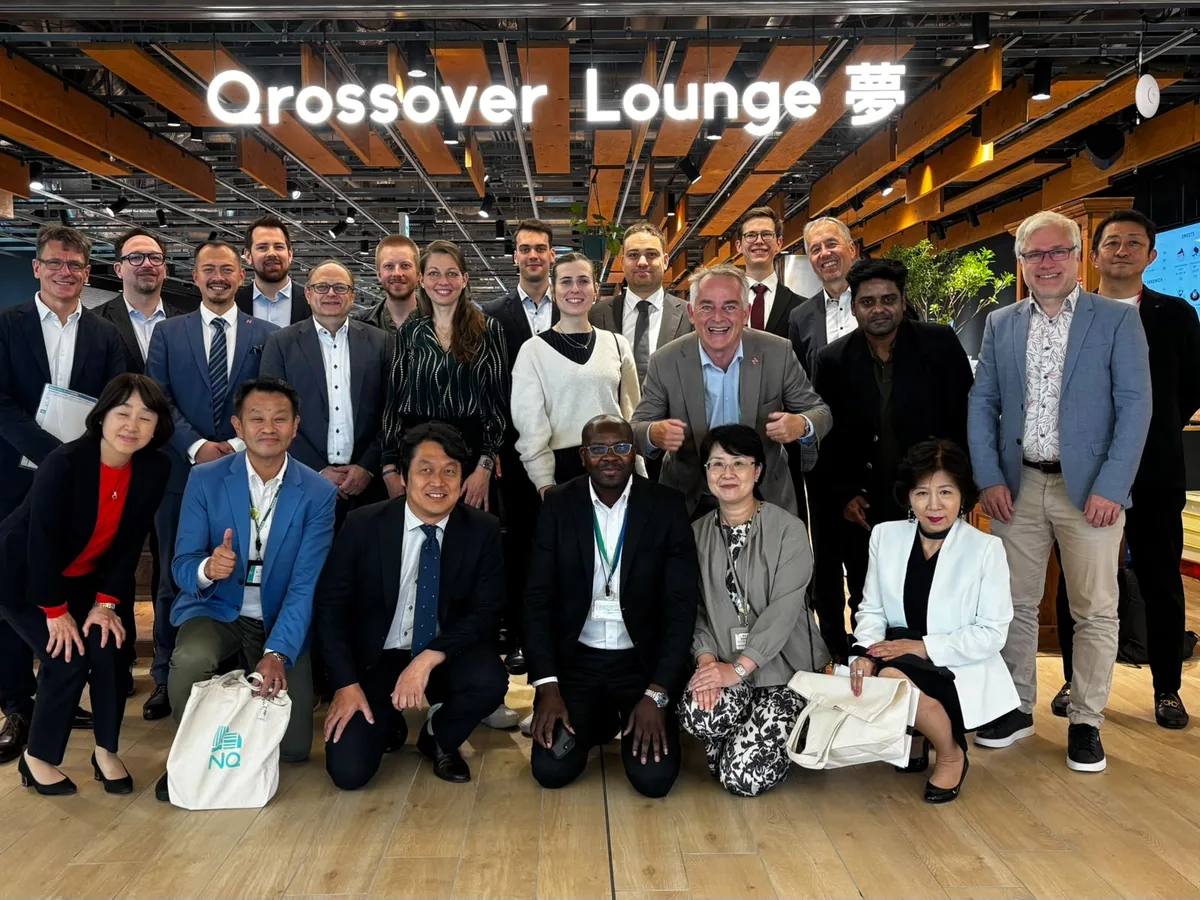 日本訪問中、Qrossover Loungeの看板の下で撮影された派遣団の集合写真。